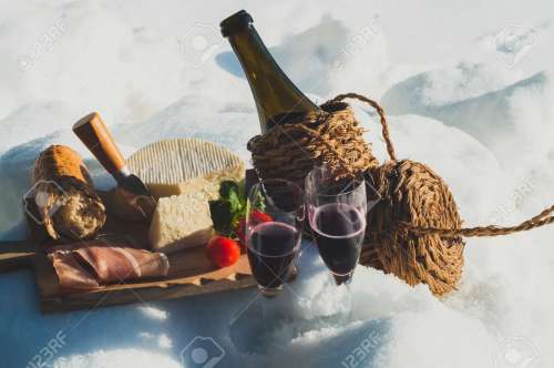161100125-romantic-picnic-with-lambrusco-cheese-baguette-and-ham-on-snow-traditional-italian-food-and-drink-ou